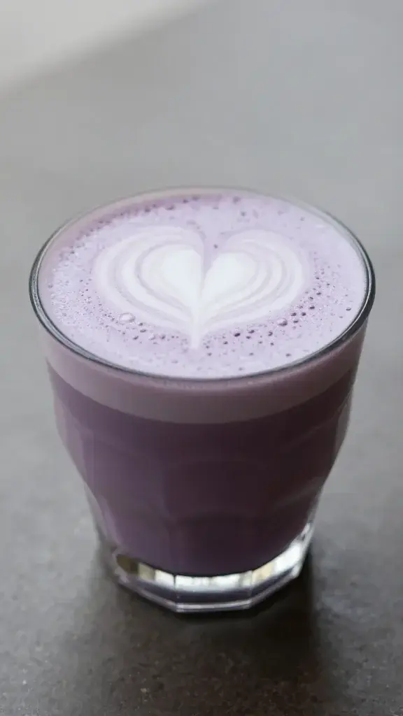 lavender latte in clear glass, microfoam heart, natural light