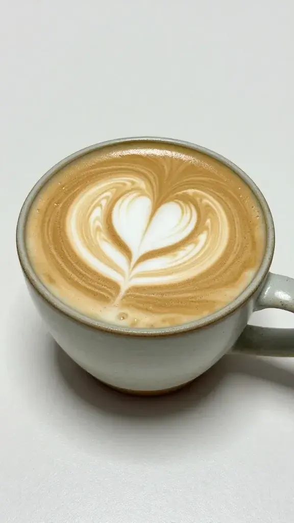 steamed milk swirl in ceramic mug, latte art heart