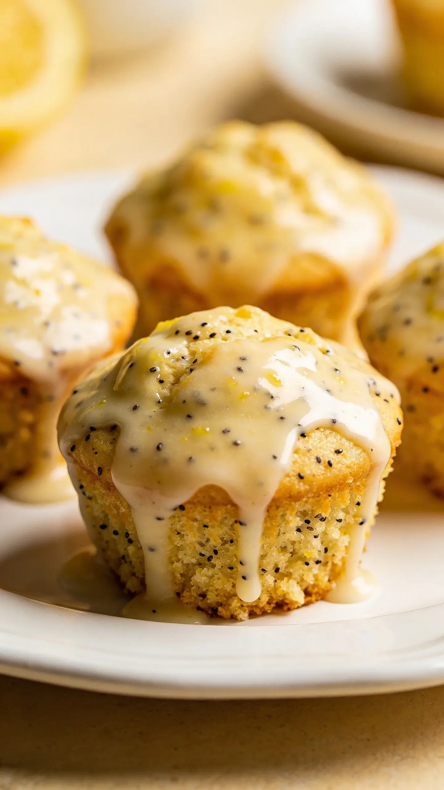 Glazed lemon poppy seed muffins on white plate, glossy glaze