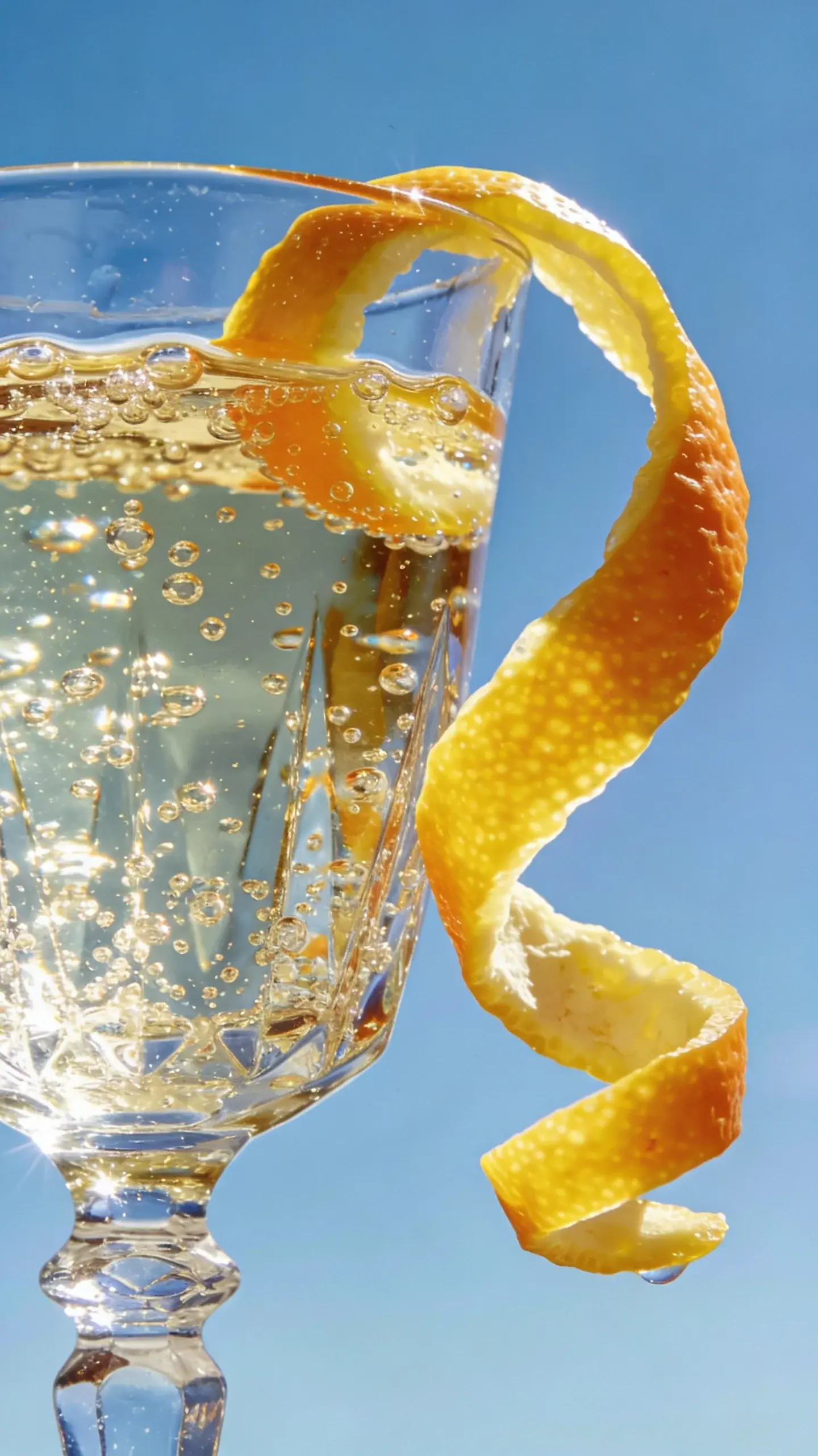 Bright bubbles in crystal glass with citrus twist garnish